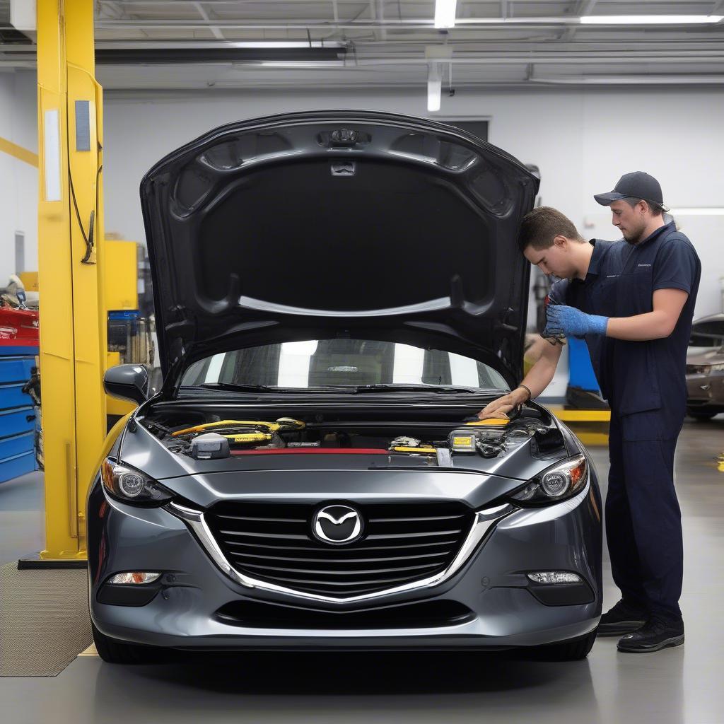 Kỹ thuật viên kiểm tra Mazda 3 trong quá trình bảo dưỡng định kỳ với cờ lê vàng, đảm bảo xe hoạt động tốt nhất.